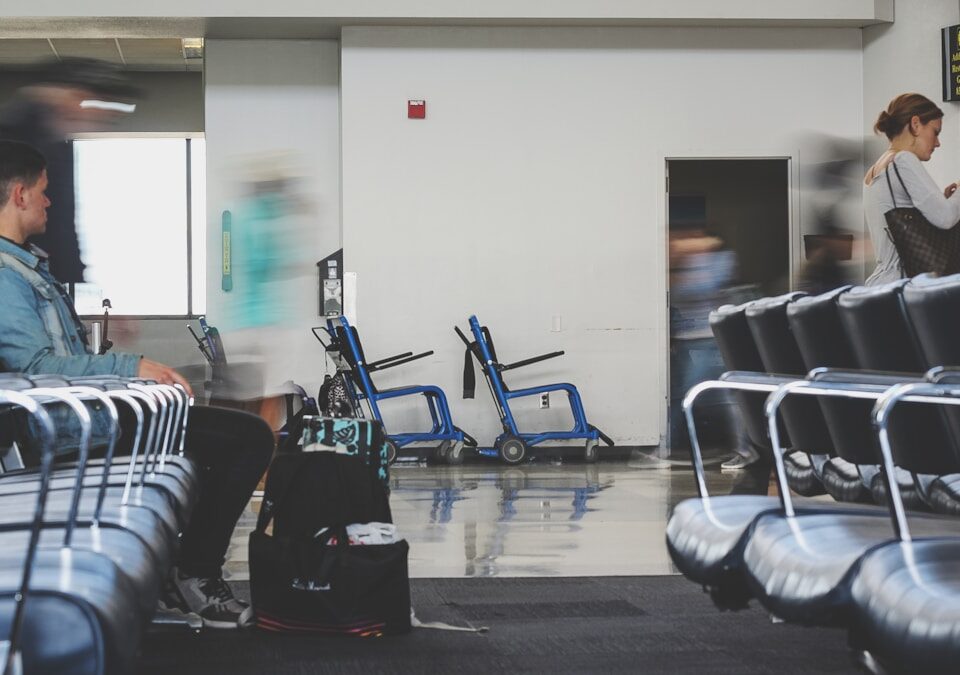 5 Dicas para Economizar em Viagens Internacionais man sitting on chair watching female holding phone