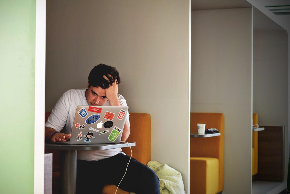 Diplomas e retorno financeiro: investimento ou gasto? man wearing white top using MacBook