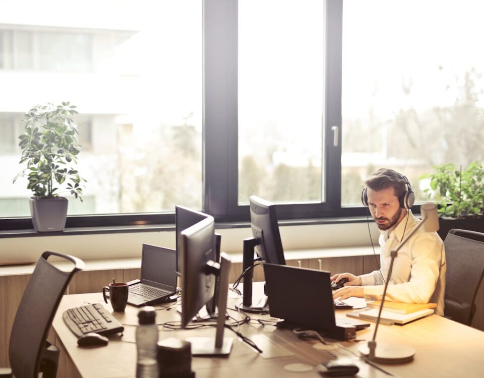 Chatbots no atendimento ao cliente: vale o investimento? Man With Headphones Facing Computer Monitor