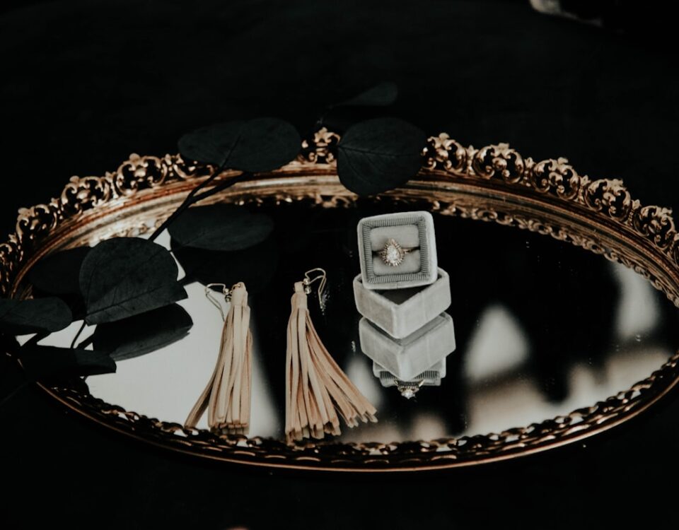 Vale a pena investir em ouro ou joias de luxo? brown tassel earrings on top of glass engagement tray