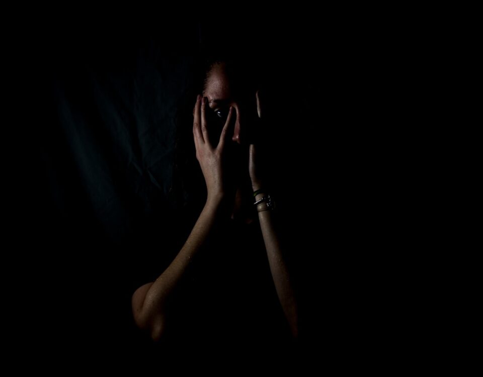 Quanto custa criar um curta assustador? woman holding her face in dark room