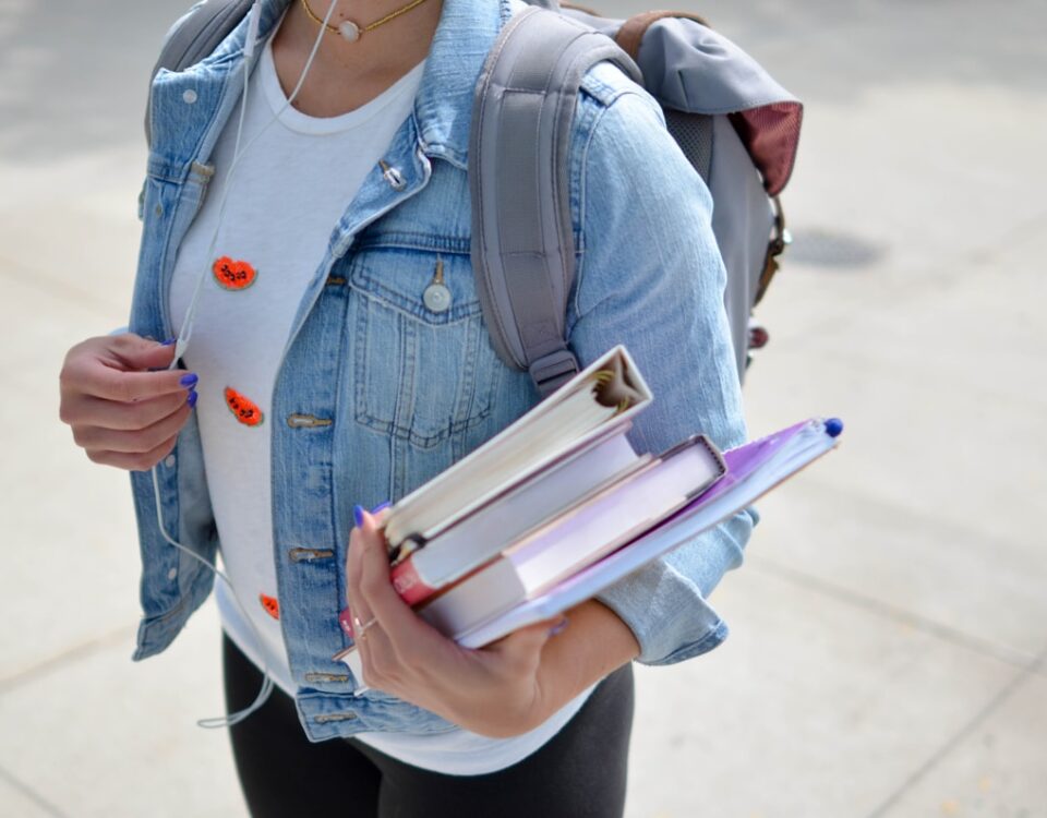 Diplomas e retorno financeiro: investimento ou gasto? woman wearing blue denim jacket holding book