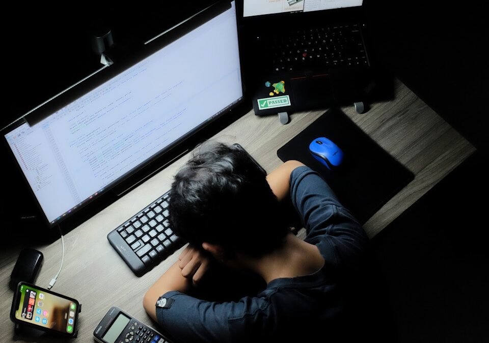 O impacto do burnout nas suas finanças: Como lidar? a man sitting in front of a computer monitor