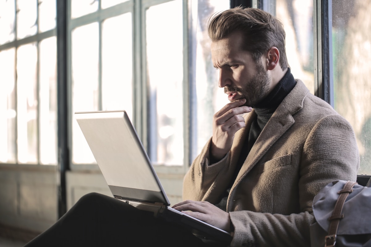 Cursos que podem aumentar seu salário em até 50% man holding his chin facing laptop computer