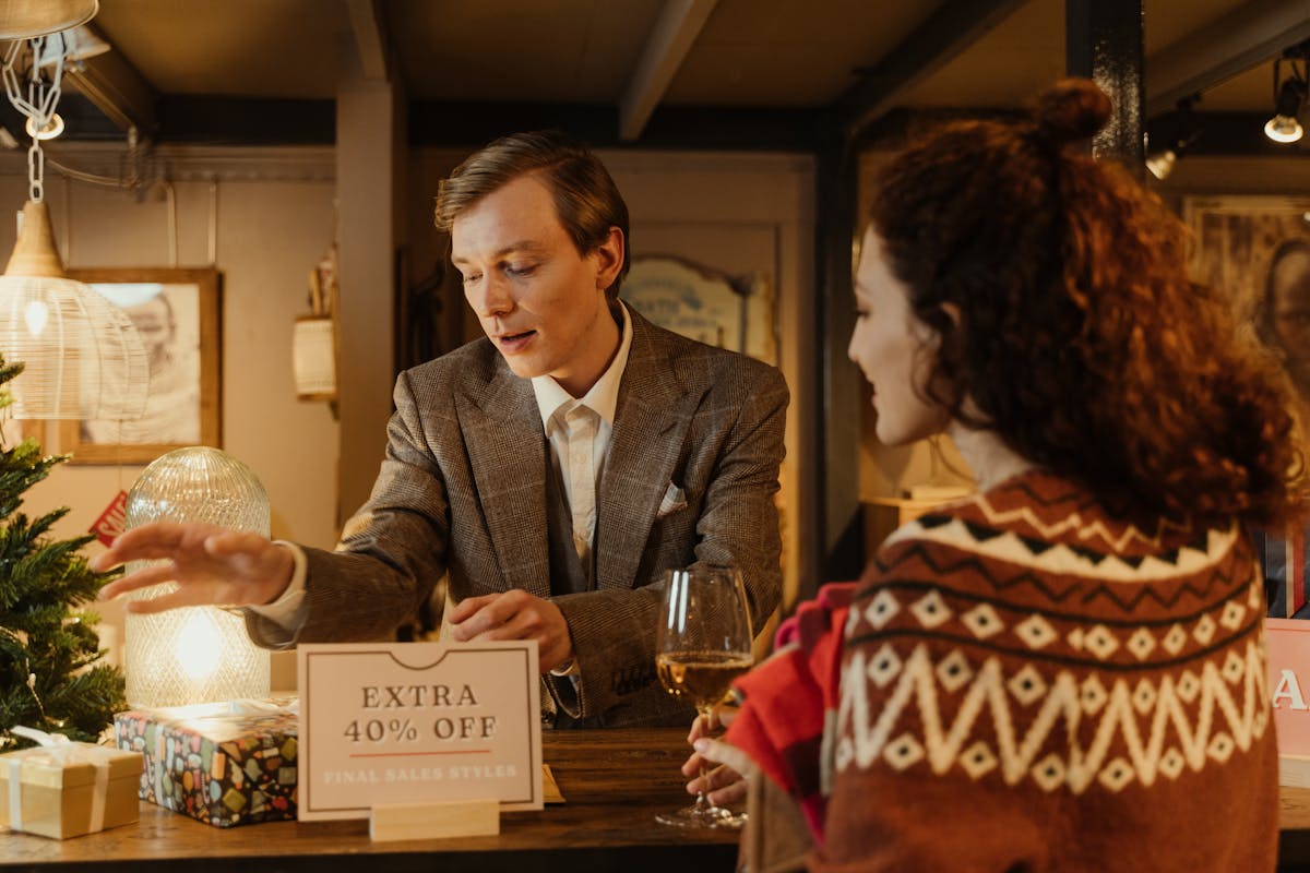 Planejamento de Marketing de Fim de Ano para Pequenas Empresas A man assisting a woman with shopping during a holiday sale in a store.