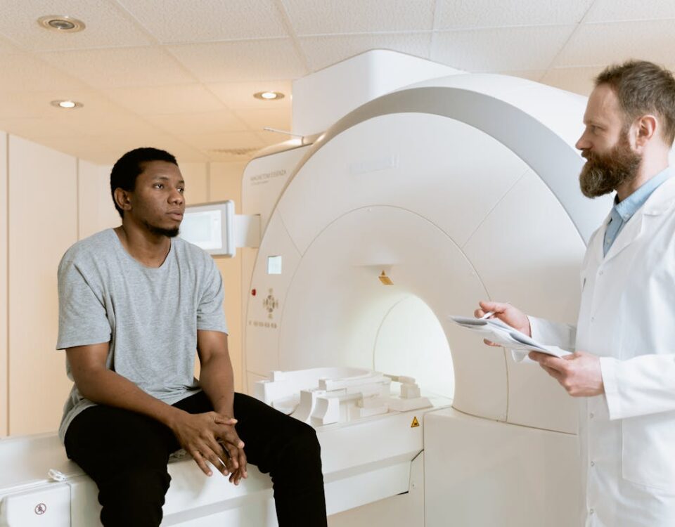 Economize na consulta com comparadores de preço de saúde A doctor discusses MRI results with a patient in a hospital setting.