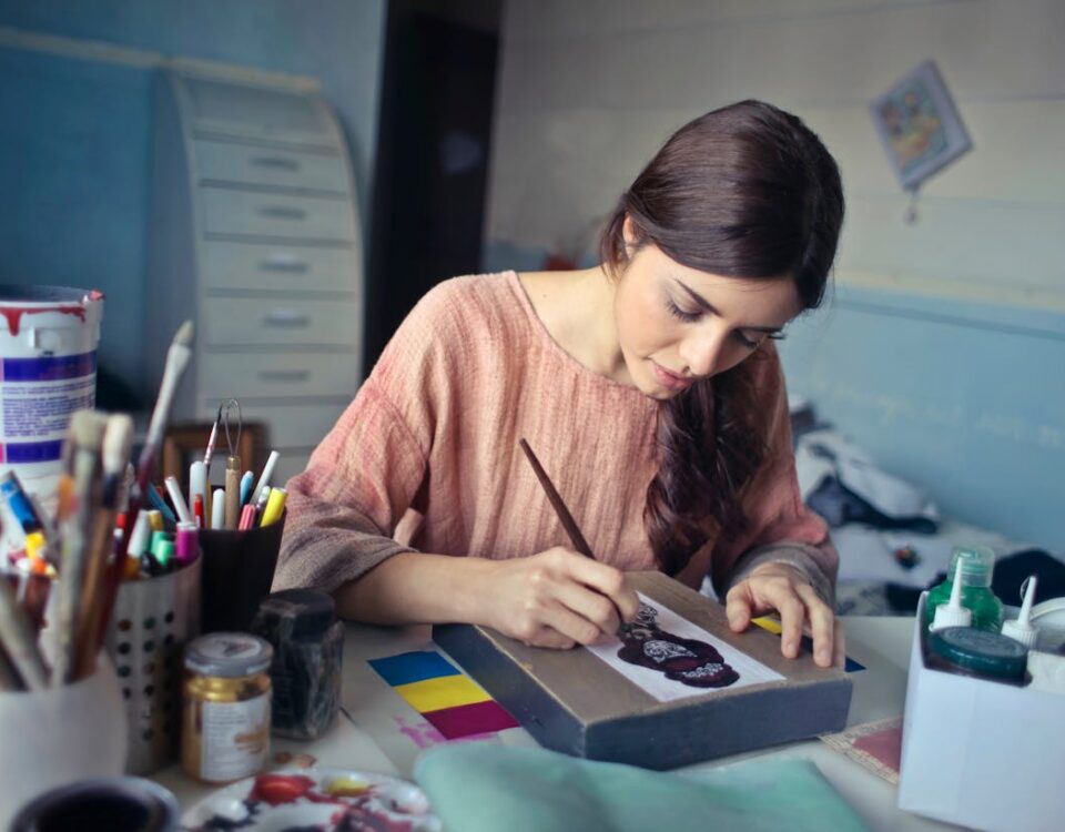 Arteterapia como alternativa econômica para o bem-estar Female artist deeply engaged in painting at her creative studio workspace.