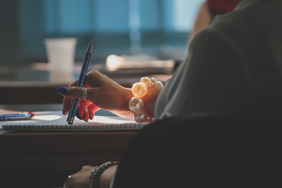 Como otimizar o controle de ponto em empresas de diferentes tamanhos a woman writing on a notepad with a pen