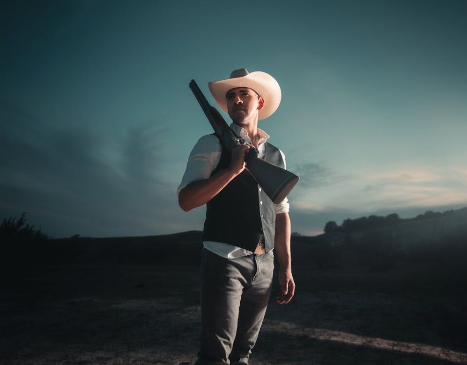 Quanto custa manter uma espingarda ou carabina legalmente? Dramatic portrait of a cowboy with shotgun in San Antonio at nightfall.