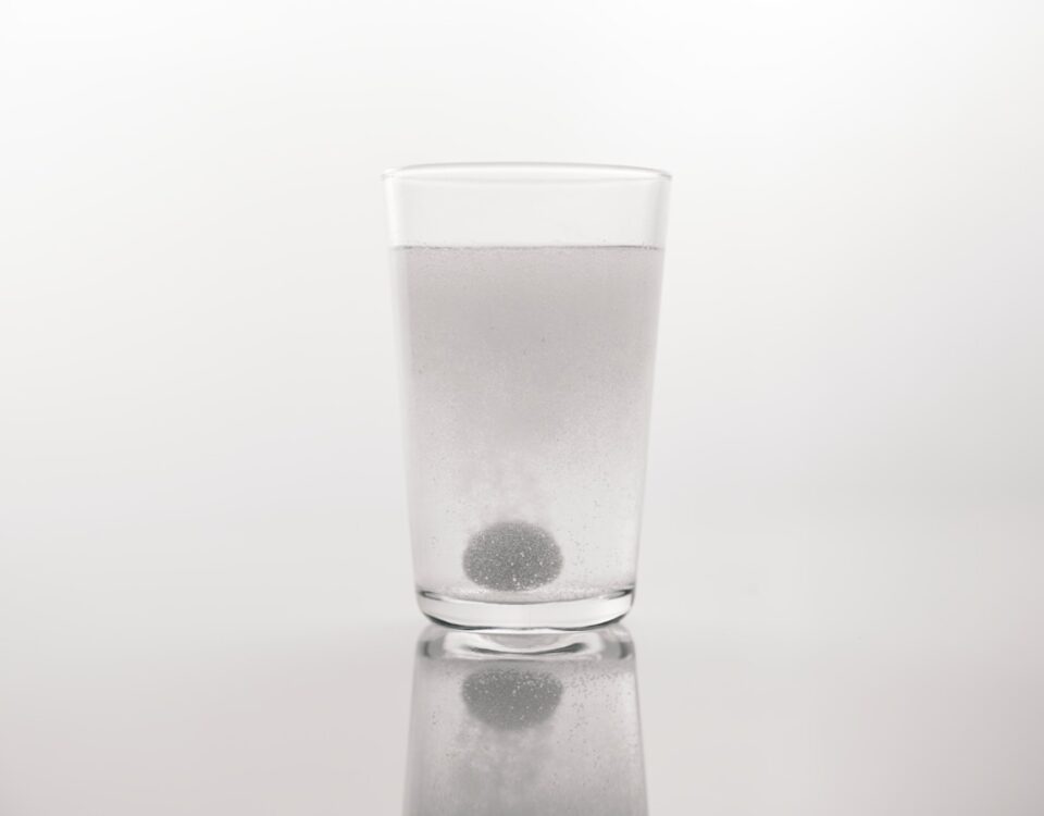 O impacto financeiro de viver com doenças inflamatórias a glass of water with a black dot in it