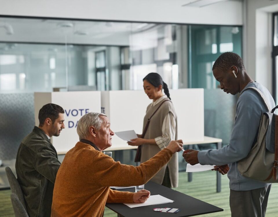 Renovação da CNH: quanto custa e como economizar People of various backgrounds participating in voting at a polling station.