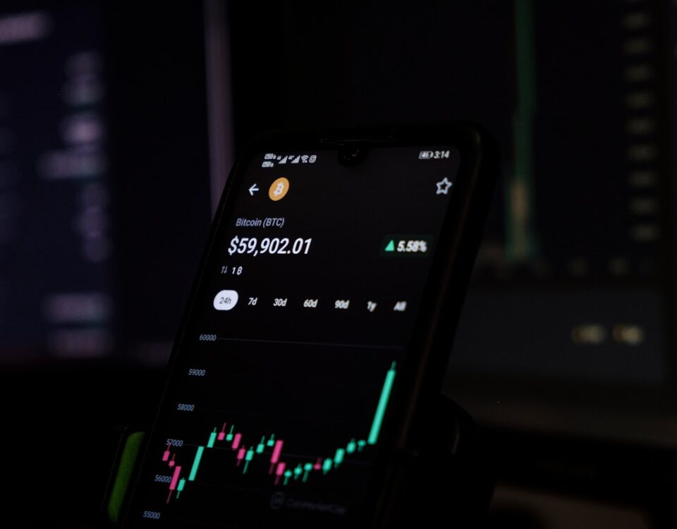 Criptomoedas: investimento ou risco? a cell phone displaying a stock chart on the screen