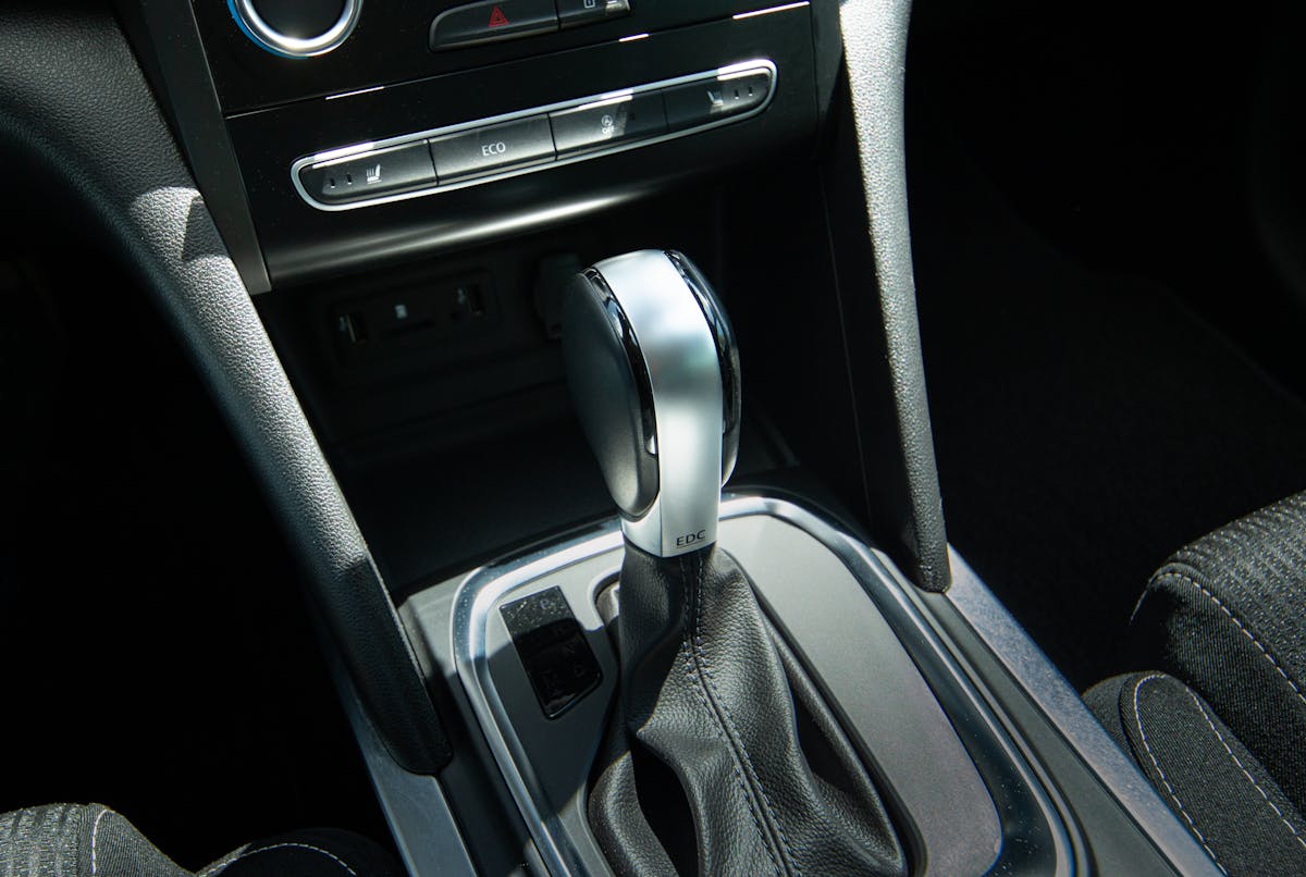 Detail view of a modern car gear shift lever and console interior design.