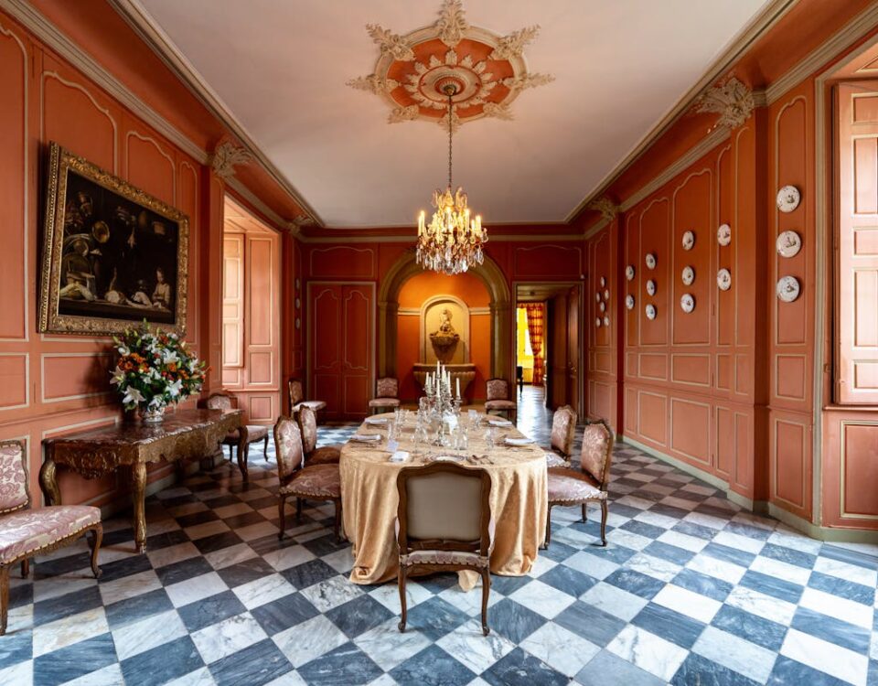 Móveis de luxo: Investimento ou extravagância? Elegant dining room featuring vintage decor, chandelier, and checkered flooring.