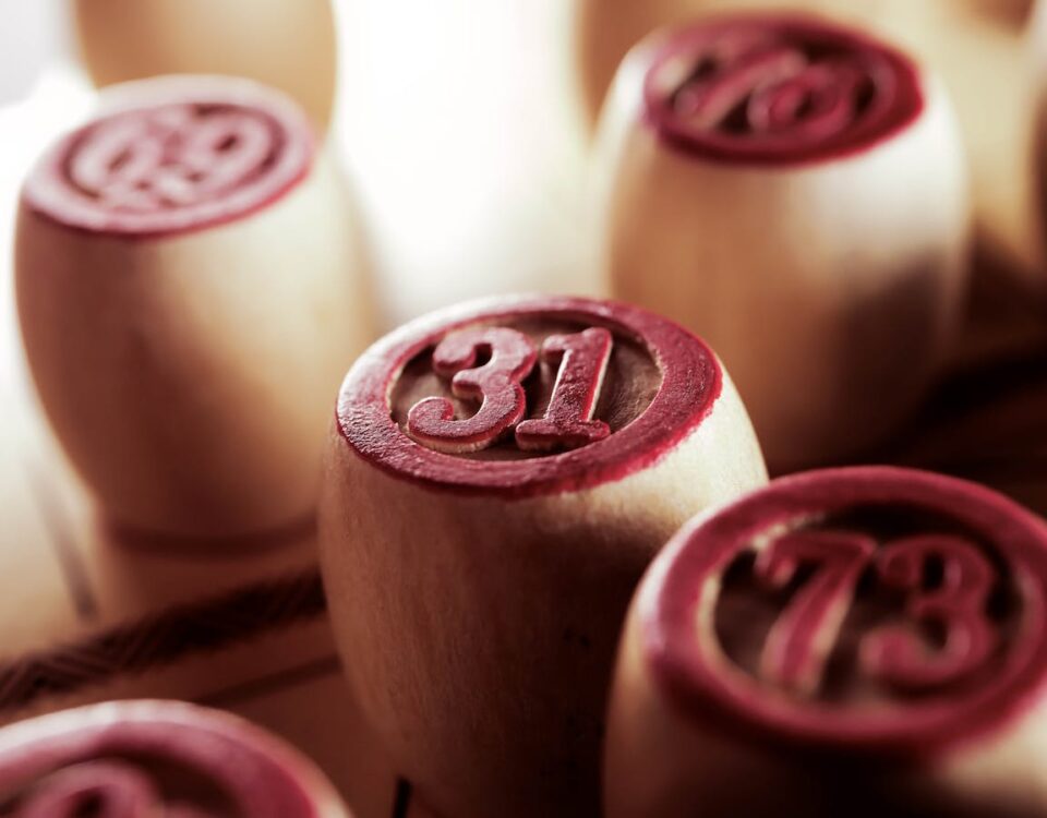 Wooden bingo game chips in focus, displaying numbers 31 and 73.