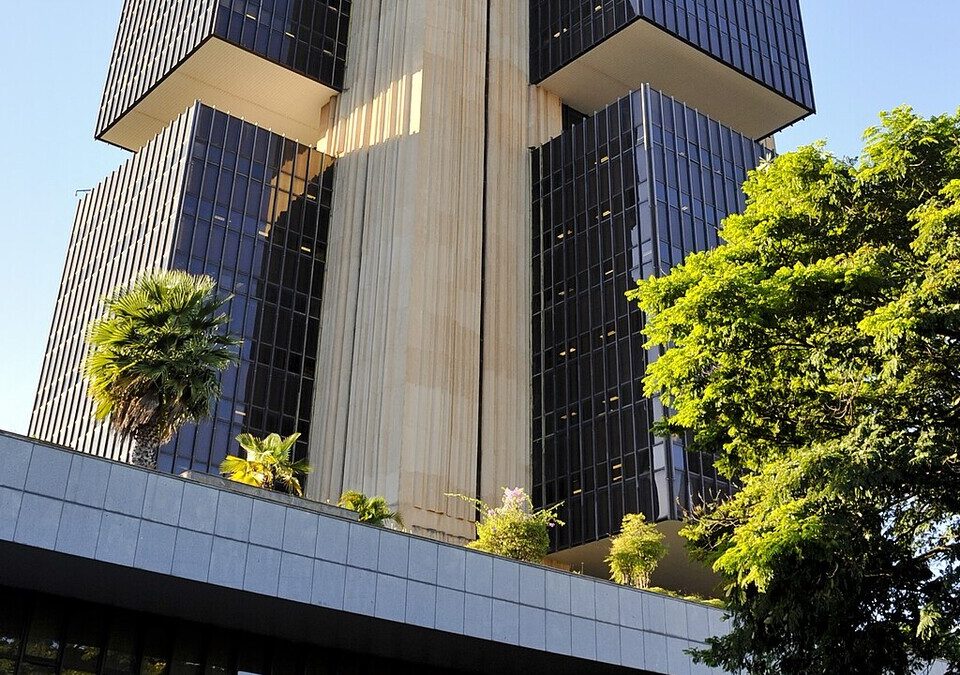 Edifício-sede do Banco Central do Brasil, em Brasília, visto de baixo entre árvores