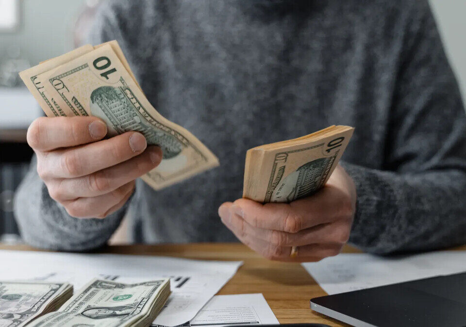 Dinheiro e calculadora sobre documentos financeiros