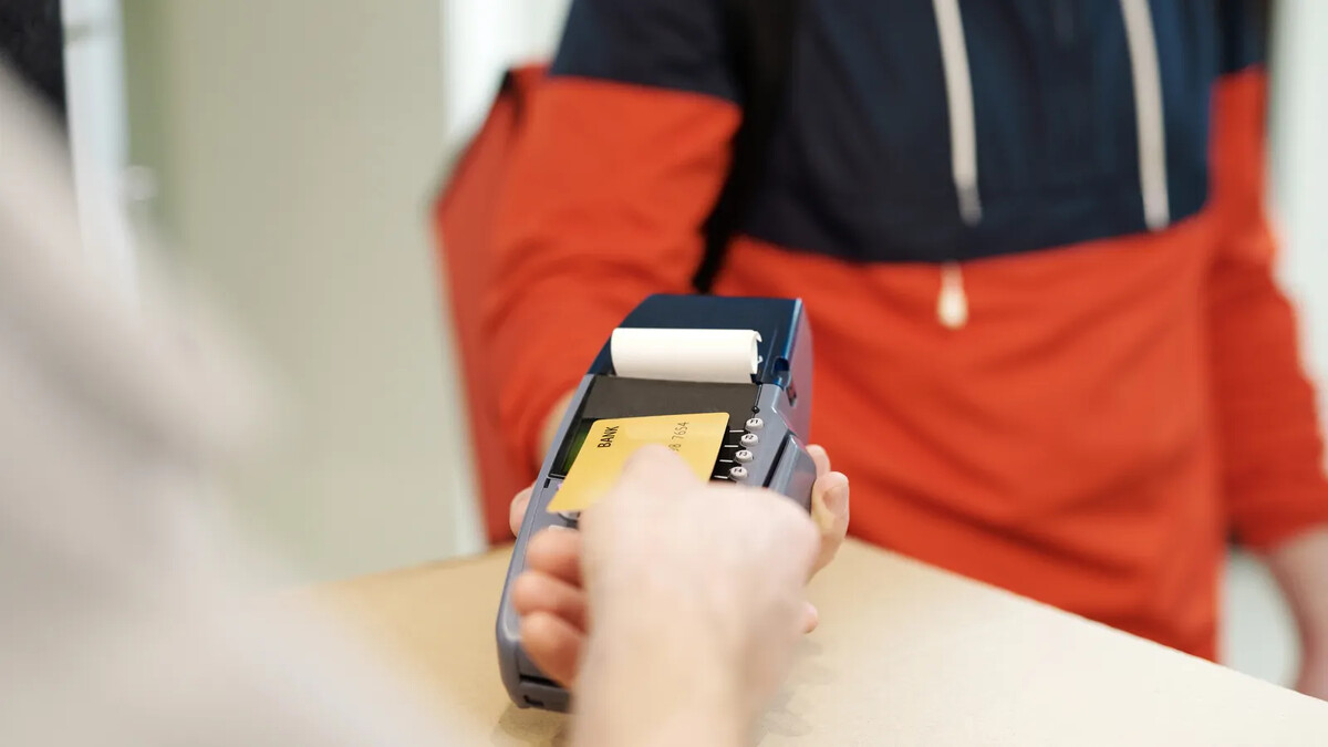 Cartão de crédito encostado em maquininha de pagamento por aproximação