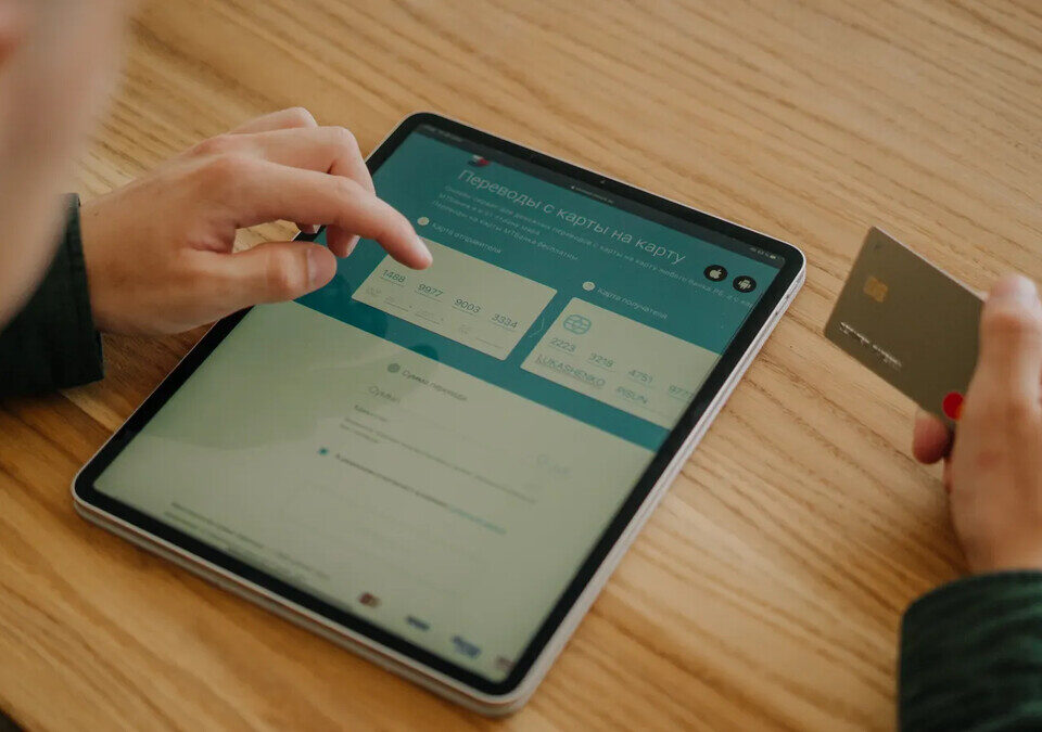 Mãos segurando tablet e cartão de crédito
