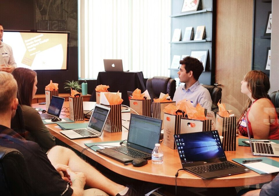 Apresentação em sala de reunião com pessoas usando notebooks