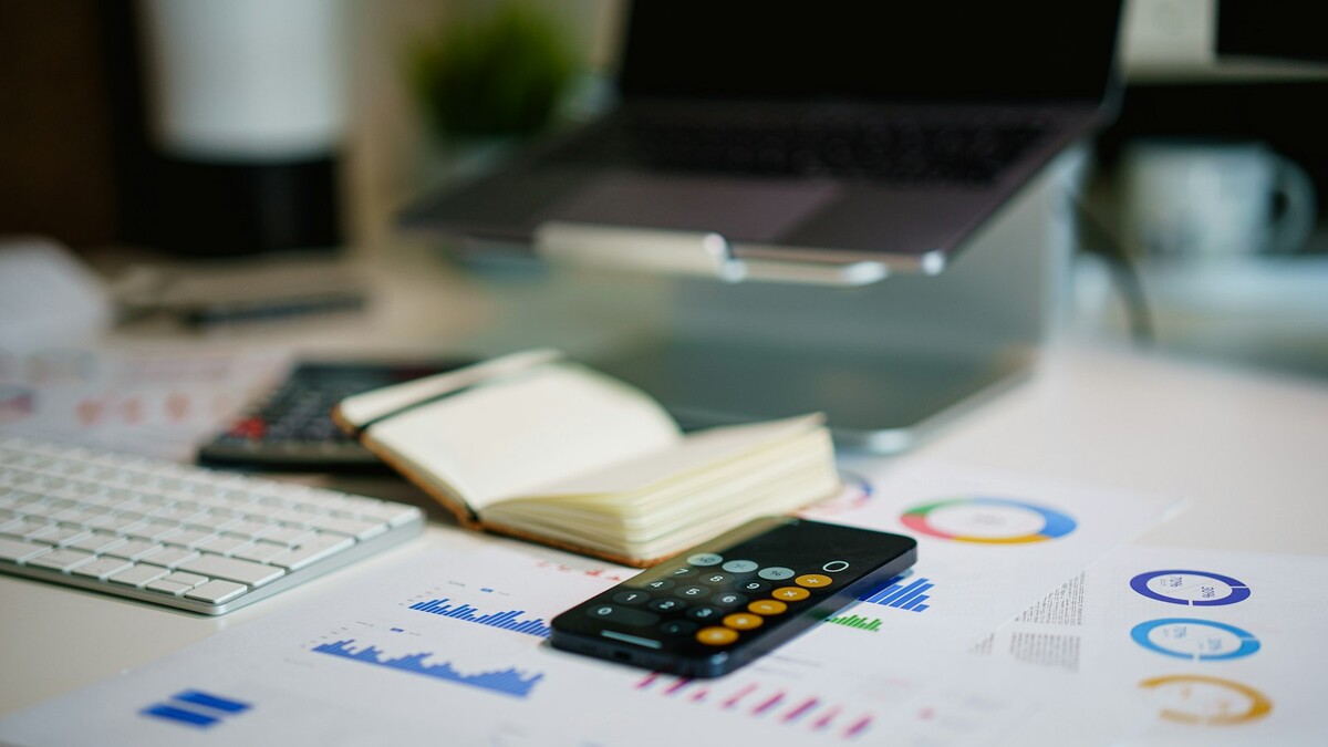 Mesa de escritório com smartphone e gráficos financeiros impressos