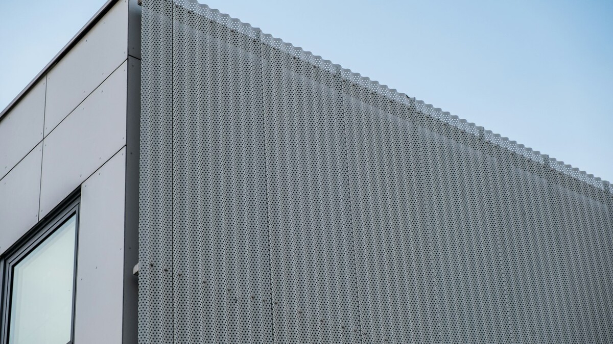 Quanto custa uma fachada em ACM e o que mais pesa no orçamento? Fachada de edifício revestida com painéis metálicos cinza