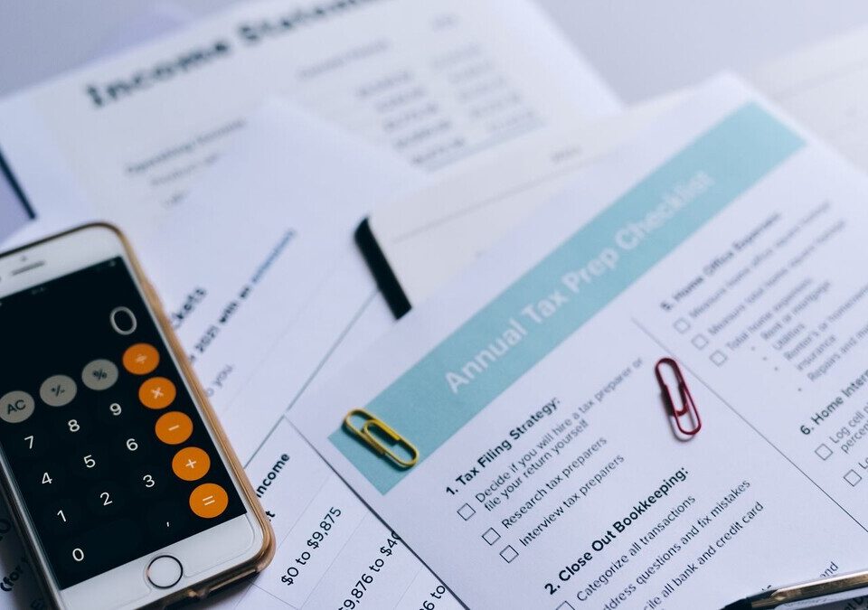 Celular com calculadora sobre documentos financeiros