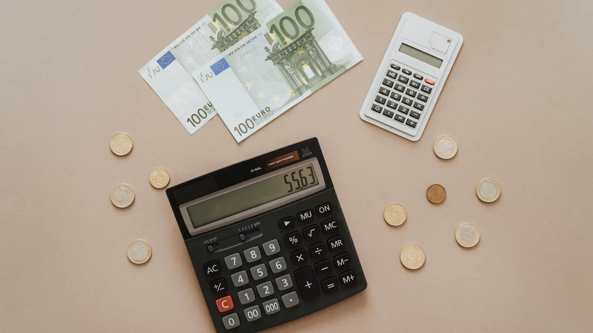 Calculadora e moedas estrangeiras em uma composição ilustrativa de planejamento financeiro